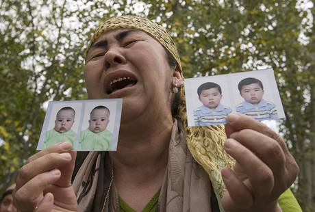 Uzbecká uprchlice s pláem ukazuje fotografie svých poheovaných vnuk