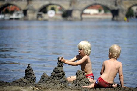 Léto ve mst. Dti si hrají v horkém poasí u Vltavy na Steleckém ostrov v Praze.