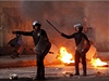 Policie prochází kolem barikády z hoících pneumatik bhem stet v Káhie