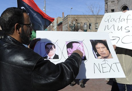 Proti Kaddfmu se demonstrovalo i v USA. Demonstrant ukazuje pekrtnut fotky tuniskho a egyptskho prezidenta, Kaddf je podle nj na ad.