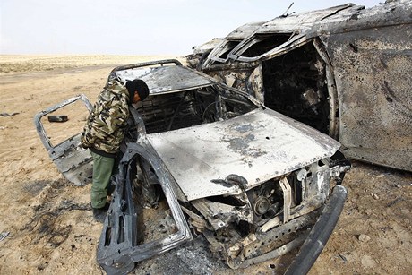 Jeden z povstalc se dívá do auta, které shoelo po bombardování NATO