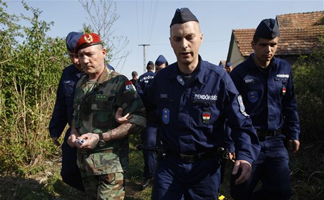 Policie (v modrých uniformách) odvádí Tamasa Eszese, éfa neonacistických hlídek v Gyöngyöspat 