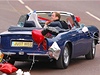 Kate a William odjídjí v modrém kabrioletu Aston Martin, který je ozdoben stukami a balonky