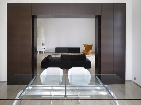 Prhled z jídelny do obývacího pokoje s pvodními kachlovými kamny a keslem od designéra Arne Jacobsena