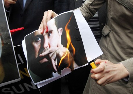 Demonstranti pálí fotografii prezidenta Baára Asada.
