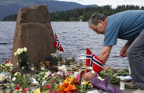 Mu pokládá norskou vlajku na ostrov Utoya k uctní památky obtí.