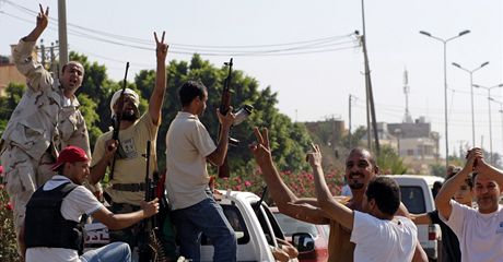 Místní obyvatelé pedmstí Tripolisu zdraví postupující vojáky opozice.