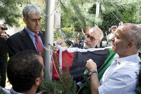 éf libyjské diplomatické kanceláe v Praze Núrí Gháví (vlevo) zavuje novou libyjskou vlajku.