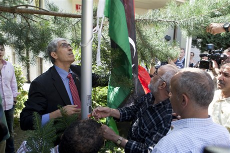 f libyjsk diplomatick kancele v Praze Nr Ghv (vlevo) zavuje novou libyjskou vlajku.