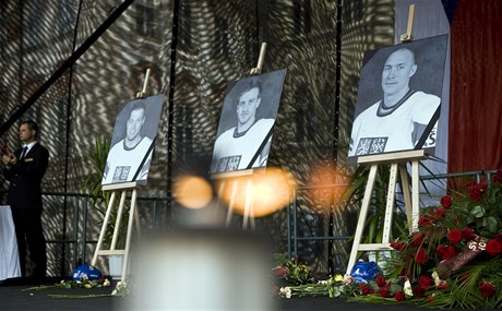 Pietní místo. Na Staromstském námstí u stojí smutení tribuna, pipravená na nedlní rozlouení. Pod fotografiemi zesnulých hokejist Josefa Vaíka, Jana Marka a Karla Rachnka lidé zapalují svíky.