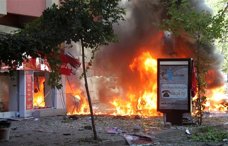 Po výbuchu ped kanceláí vládního úadu zachvátily ulici plameny. 