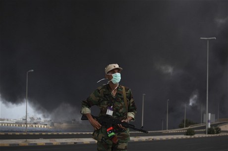 Libyjský rebel u hoícího armádního skladu v Tripolisu. 