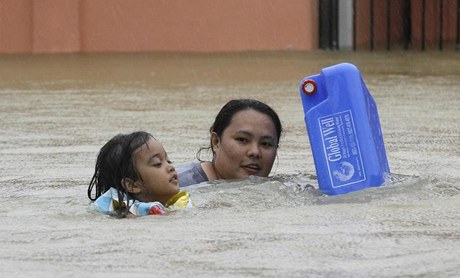 S kanystrem pro pitnou vodu.  Matka dít se snaí ulicemi filipínského msta Calumpit dostat k nezávadné vod. 