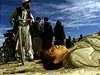 Afghántí civilisté na snímku z roku 2001 projídjí kolem tl zabitých Talibanc