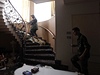 Povstalci stoupají po schodech vzhru do patra domu jednoho z len Kaddáfího rodiny.