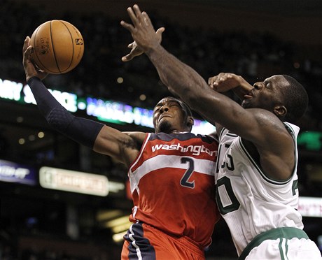 Zápas NBA mezi Washingtonem Wizards a Bostonem Celtics. Basketbalista Washigtonu John Wall (vlevo) se pokouí o zavení, Brandon Bass z Bostonu se mu v tom snaí zabránit.