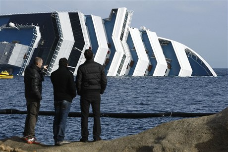 Lidé pozorují ztroskotanou lo Costa Concordia.