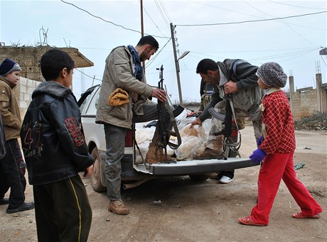 Bývalí syrtí vojáci rozdávají jídlo dtem z oblasti Rastan v provincii Homs.