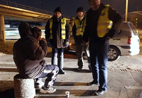 Bezdomovec ve trasburku mluví s dobrovolníky z charitativní organizace.