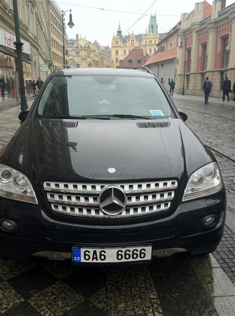 Foto z facebookové stránky asopisu Forbes: Mercedes s kmotrovskou SPZ a znakou invalidy parkuje na chodníku.