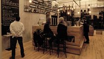 Hlavními motivy interiéru jsou dubový solitérní bar a v ocelových koších zavěšené stovky vinných lahví. Celkové atmosféře napomáhá i odhalená konstrukce kleneb, dubová podlaha a zavěšené žárovky. | na serveru Lidovky.cz | aktuální zprávy