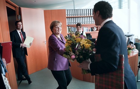 editel Lidových novin Dalibor Balínek pedává Angele Merkelové kytici. Ta si ji v záptí odnese do vázy.