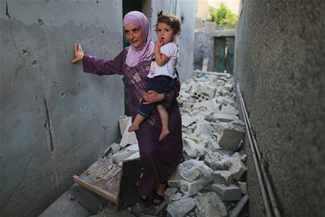 Matka s díttem prochází znienou tvrtí v Aleppu