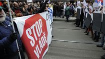 Účastníci happeningu s kartony zobrazujícími členy vlády v přilbách a se štíty bývalé komunistické SNB | na serveru Lidovky.cz | aktuální zprávy