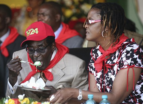 Prezident Zimbabwe, Robert Mugabe, ochutnává svj narozenínový dort.