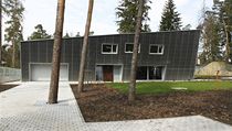 Pohled od hlavního vchodu. Dům, jehož čelní fasáda je obložena poloprůsvitným vlnitým laminátem známým ze zemědělských a průmyslových objektů, se nachází v nejvzdálenější části pozemku. | na serveru Lidovky.cz | aktuální zprávy