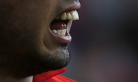 Fotbalista Liverpoolu Luis Suárez ukazuje zuby, kterými pokousal protihráe