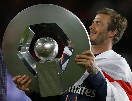 Fotbalista Paris St. Germain David Beckham s trofejí pro vítze francouzské ligy