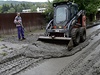 Bagr shrnuje vrstvu bahna na silnici. (Vrané nad Vltavou, 7. ervna)