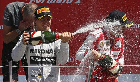 Nico Rosberg (vlevo) vyhrál Velkou cenu Británie a "sprchuje" Alonsa.