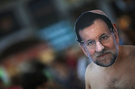 V Madridu proti Rajoyov vlád protestují. Zde demonstrant s maskou premiéra 
