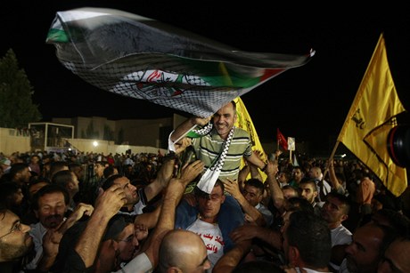 Proputný vze Esmat Mansour (uprosted) na rukou nadených Palestinc