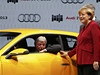 Nmecký premiér Hesenka Volker Bouffier si zkouí nový sportovní vz znaky Audi. Merkelová stojí vedle nj. 