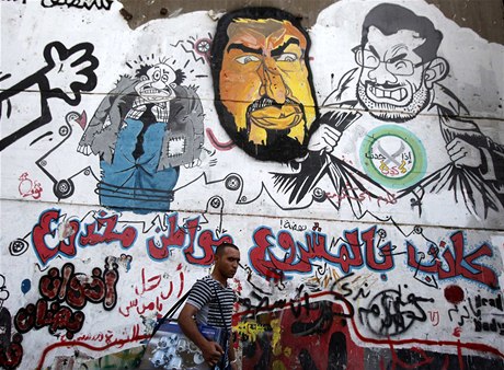 Káhirské graffiti zobrazuje svreného prezidenta Mursího (vpravo) a zastupujícího vdce Muslimského bratrstva Chajráta atira (uprosted)  