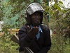 Keský policista stojí ped dobchodním domem, ze kterého stoupá dým