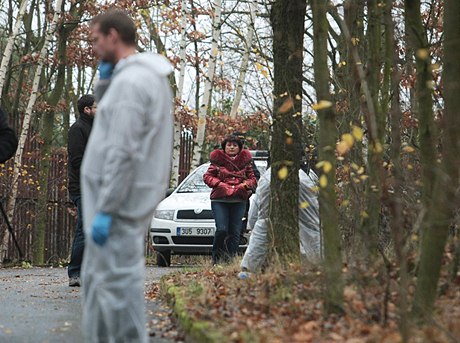 Policie pracuje u zadní ásti domu. V pozadí stojí Jana Vahová.