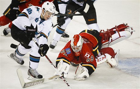 eský hokejista San José Sharks Tomá Hertl (vlevo) a branká Calgary Flames Reto Berra 
