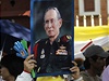 Demonstrantka drí nad hlavou transparent s portrétem thajského krále Pchúmipchona Adunjadéta 