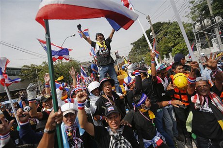 Protivládní demonstranti mávají thajskou vlajkou. Oslavují prnik do areálu policejního ústedí