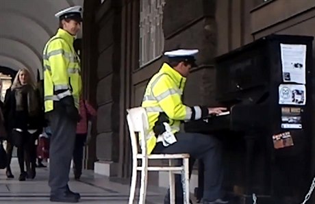 Policista hraje ped filosofickou fakultou na piano.