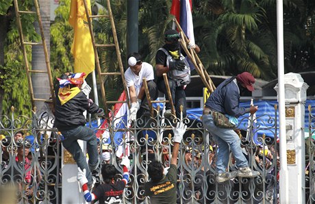Demonstranti pelézají plot kolem vládní budovy
