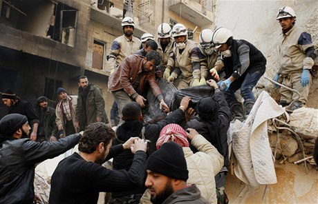 Písluníci Syrské svobodné armády vyproují mrtvá tla ze sutin  budovy zniené nálety