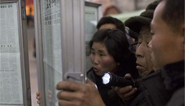 Severokorejci se v pchjongjangskm metru shromauj kolem vyvench novin, kter informuj o odstrann ang Song-tcheka