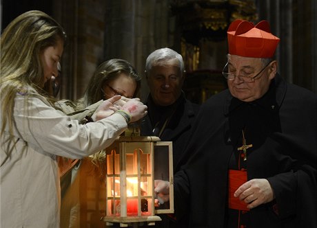 Kardinál Dominik Duka pebírá od skaut Betlémské svtlo.