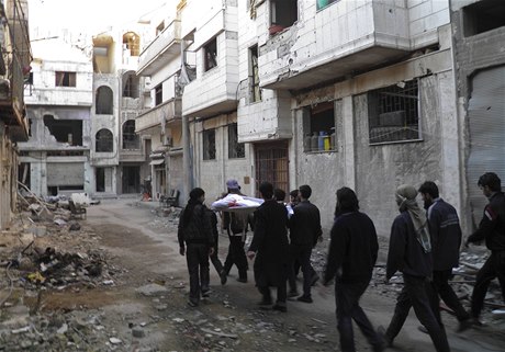 Povstalci nesou tlo mue zabitého odstelovaem patícím k silám prezidenta Baára Assada, Homs, Sýrie. 