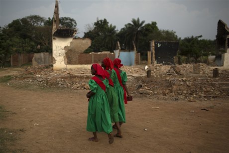 Dívky písluící ke kesanské sekt prochází kolem trosek meity v Bangui